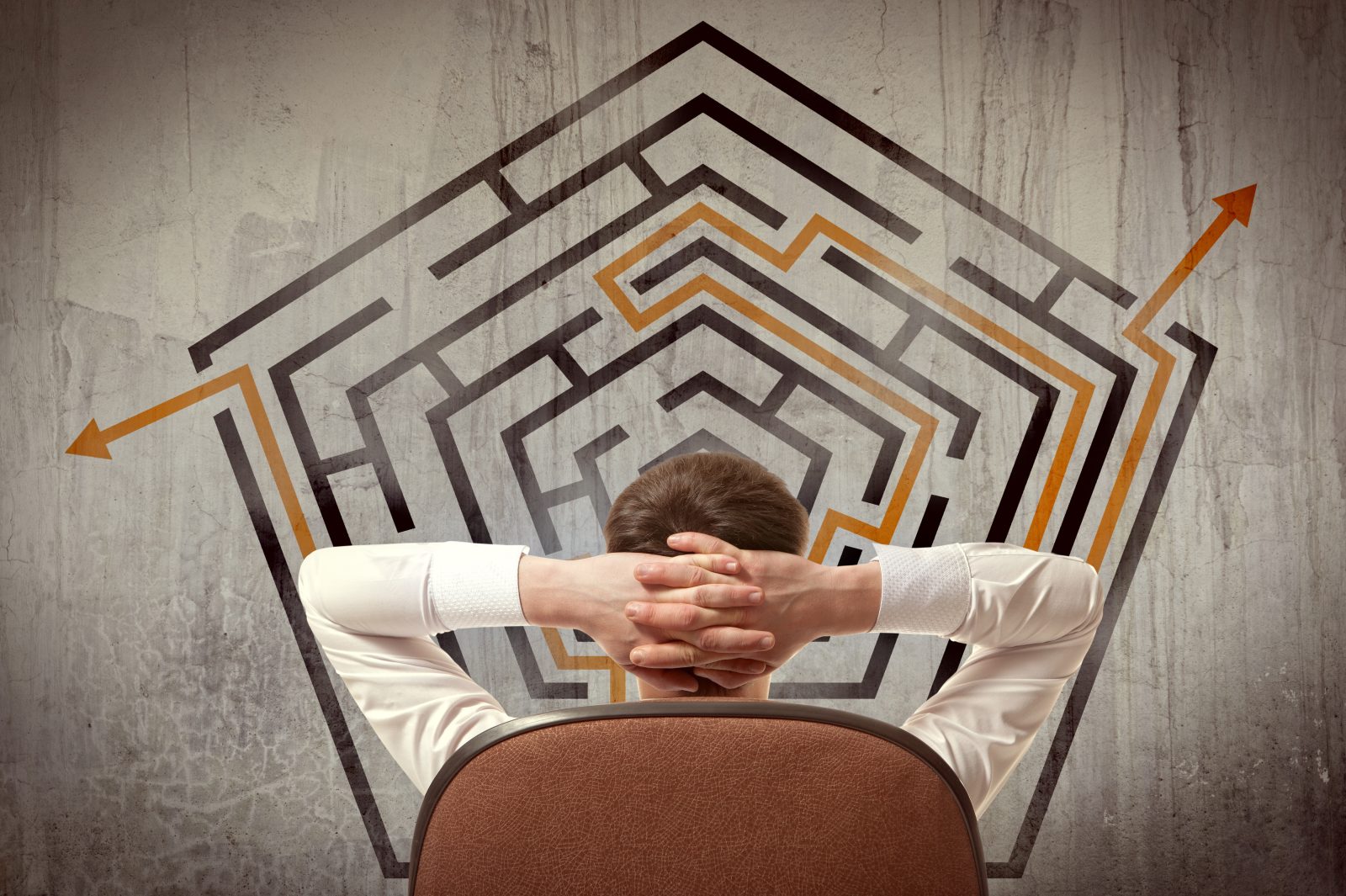 Man with hands clasped considers exit options over maze graphic