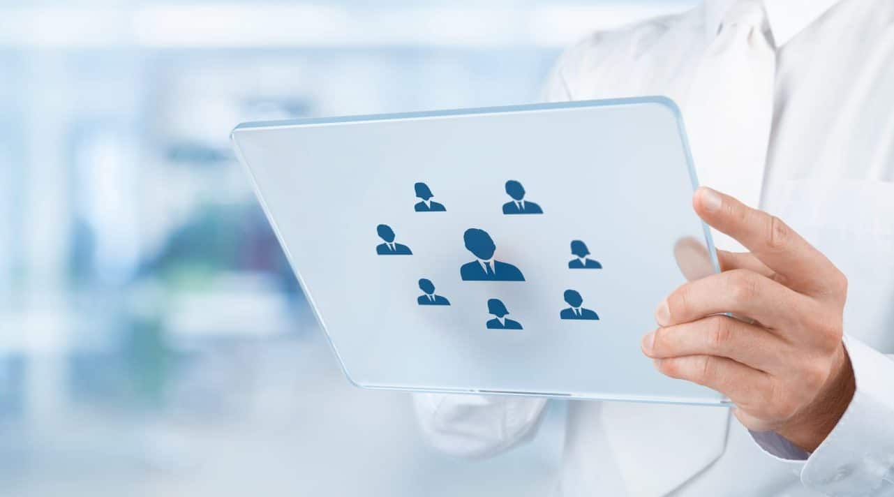 Man holding glass tablet featuring team avatars